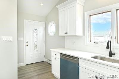190 Bayview Ave, Lindenhurst, NY 11757 - kitchen featuring stainless steel dishwasher, a sink, white cabinetry, light countertops, and light wood-style floors