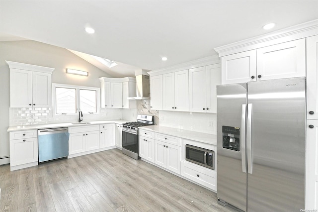 190 Bayview Ave, Lindenhurst, NY 11757 - kitchen with stainless steel appliances, wall chimney exhaust hood, lofted ceiling, a skylight, and decorative backsplash
