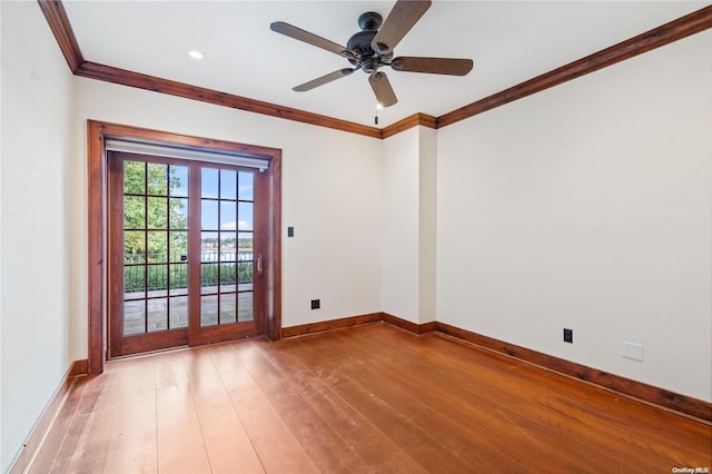 spare room featuring french doors, hardwood / wood-style flooring, ceiling fan, and crown molding