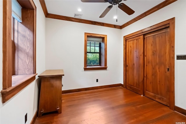 unfurnished bedroom with wood-type flooring, ceiling fan, and crown molding