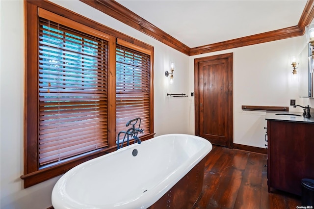 bathroom featuring wood-type flooring, vanity, a tub to relax in, and ornamental molding