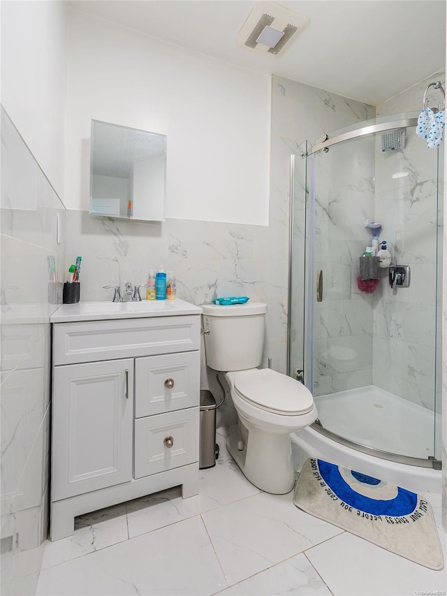 bathroom featuring vanity, toilet, an enclosed shower, and tile walls