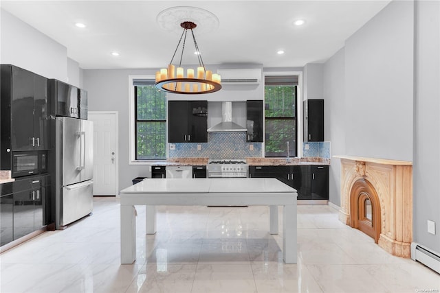 kitchen with a wealth of natural light, stainless steel appliances, wall chimney range hood, and decorative light fixtures