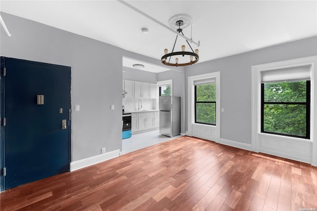 unfurnished living room with light wood-type flooring and sink