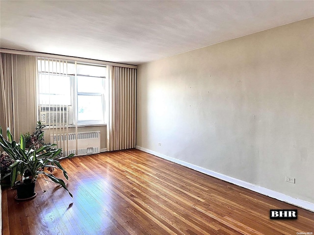 empty room with radiator and wood-type flooring