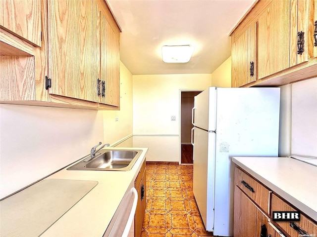 kitchen featuring dishwasher, sink, and white refrigerator