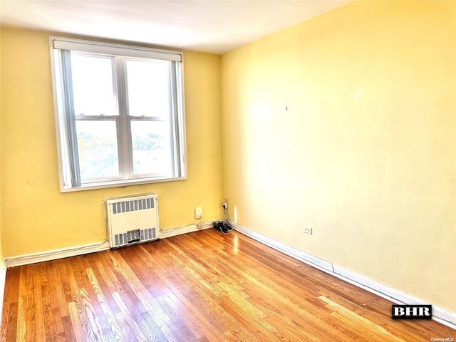 unfurnished room with light wood-type flooring and radiator