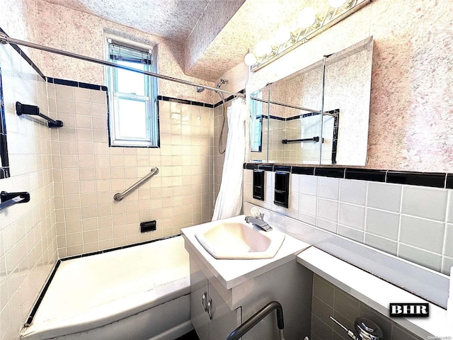 bathroom with vanity, tile walls, and shower / tub combo with curtain