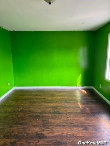 spare room featuring dark wood-type flooring