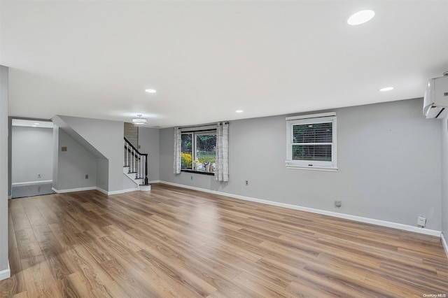 interior space featuring light wood-type flooring and an AC wall unit