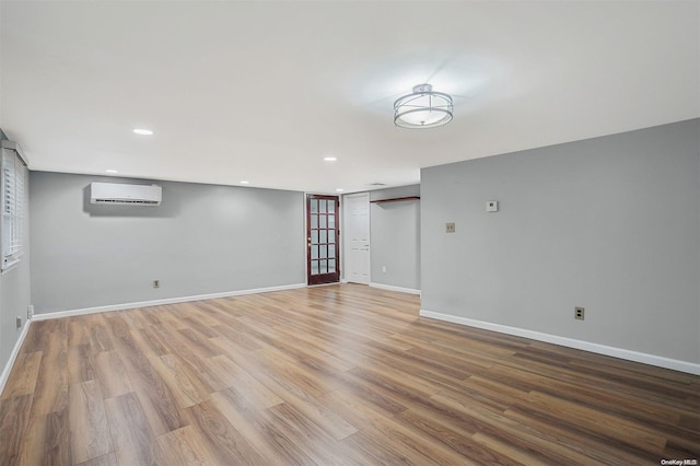 empty room featuring hardwood / wood-style floors and a wall mounted AC