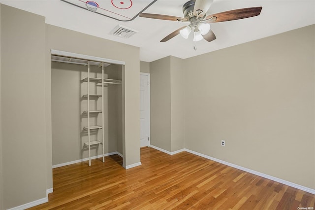 unfurnished bedroom with hardwood / wood-style floors, a closet, and ceiling fan