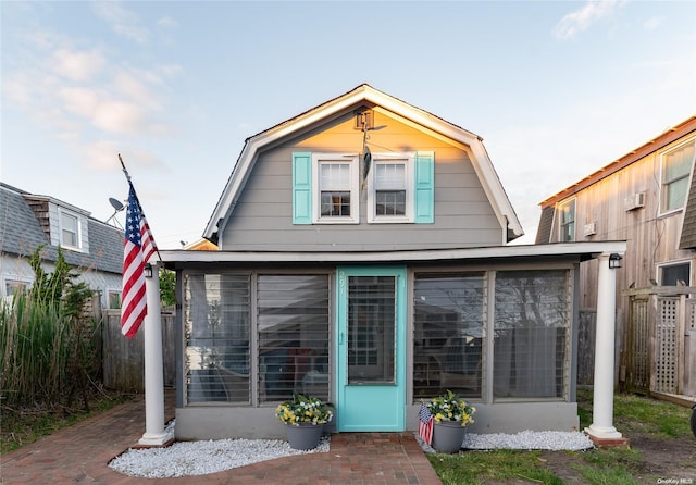 rear view of house featuring a sunroom