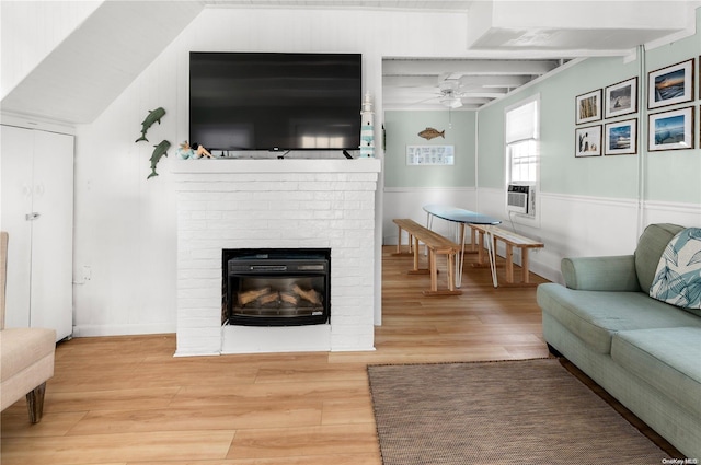 living room with hardwood / wood-style flooring, a brick fireplace, ceiling fan, and cooling unit