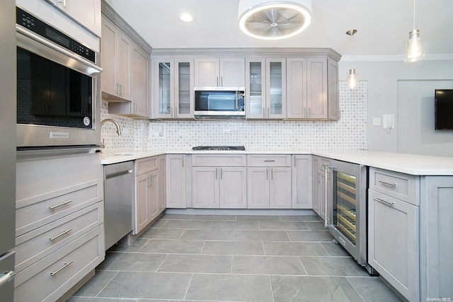 kitchen featuring beverage cooler, tasteful backsplash, decorative light fixtures, gray cabinets, and appliances with stainless steel finishes