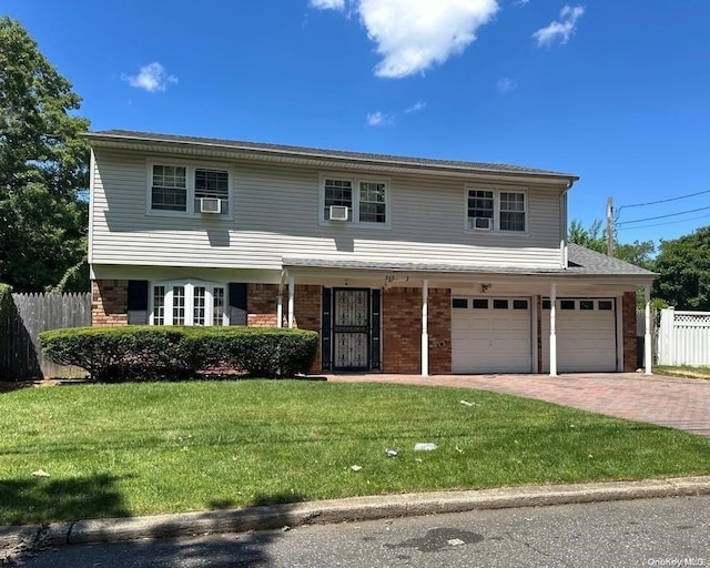 view of front of home featuring cooling unit, a garage, and a front lawn