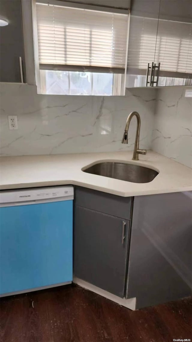 kitchen with backsplash, dishwasher, dark wood-type flooring, and sink