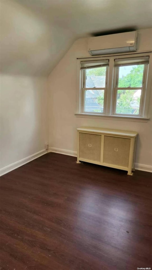 48-27 213th St, Bayside, NY 11364 - additional living space with radiator, a wall mounted AC, wood finished floors, and vaulted ceiling