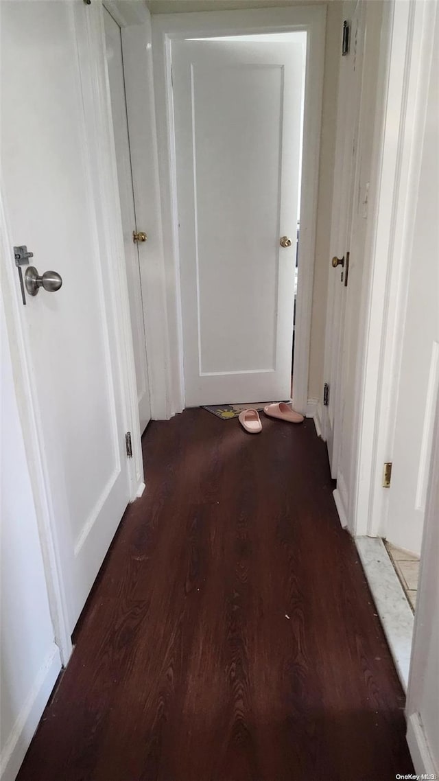 corridor with dark hardwood / wood-style flooring