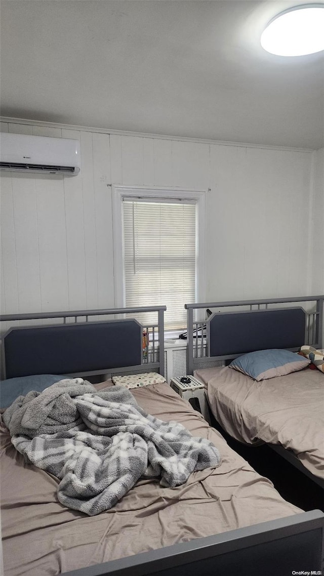 bedroom with a wall unit AC and wood walls