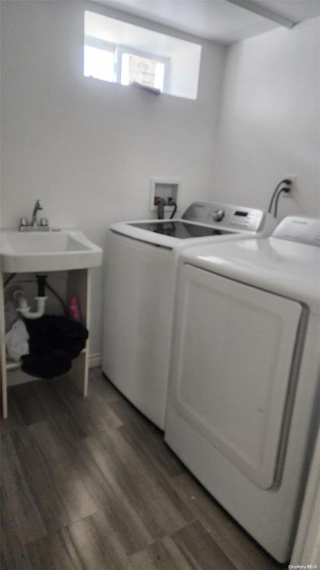 washroom with washing machine and clothes dryer and dark hardwood / wood-style floors