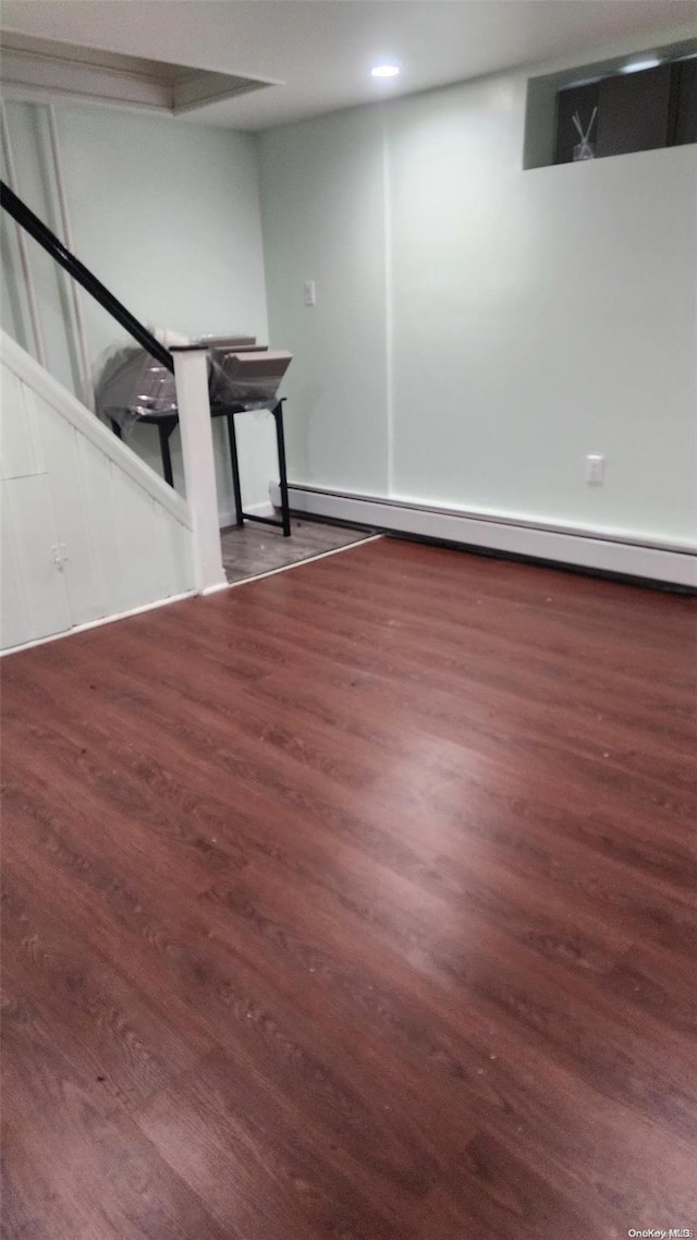 basement featuring dark hardwood / wood-style floors and baseboard heating