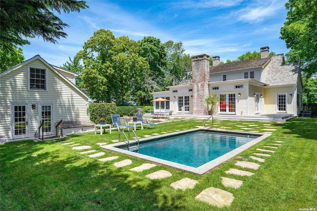 rear view of house featuring a lawn, a patio area, central air condition unit, and french doors