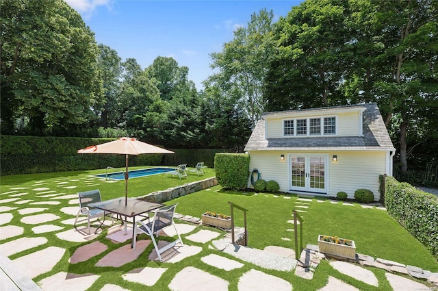 rear view of property with french doors, a patio, a fenced in pool, and a lawn