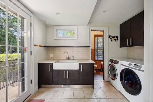 laundry area featuring plenty of natural light, cabinets, sink, and washing machine and dryer