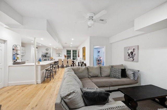 living room featuring light wood-type flooring and ceiling fan