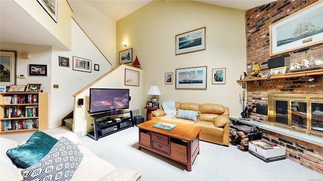 carpeted living room featuring a fireplace and high vaulted ceiling