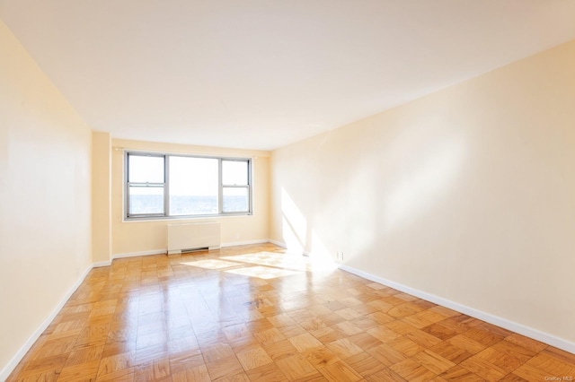 unfurnished room featuring light parquet floors and radiator