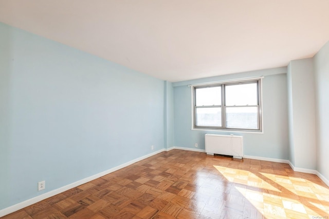 unfurnished room featuring radiator and parquet floors