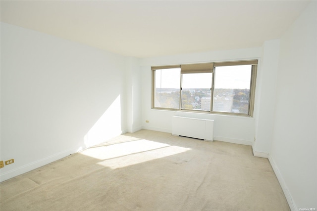 carpeted spare room featuring radiator