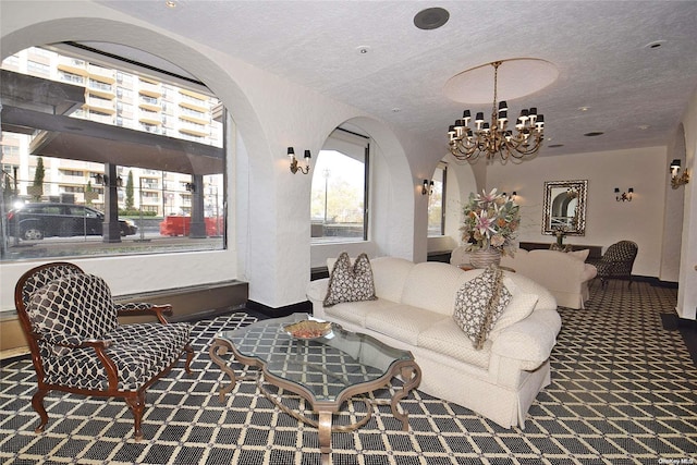 living room with dark colored carpet, a textured ceiling, and a notable chandelier