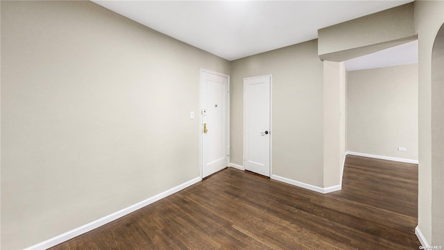 empty room with dark hardwood / wood-style flooring