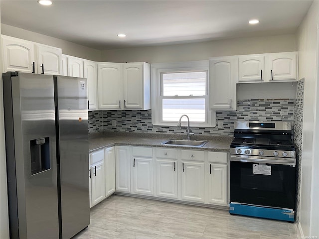 kitchen featuring white cabinets, backsplash, stainless steel appliances, and sink