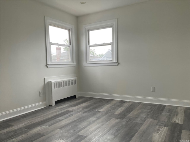 unfurnished room featuring dark hardwood / wood-style flooring and radiator