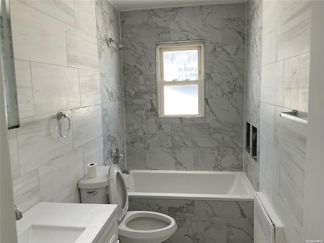 full bathroom with radiator, vanity, tile walls, toilet, and tiled shower / bath