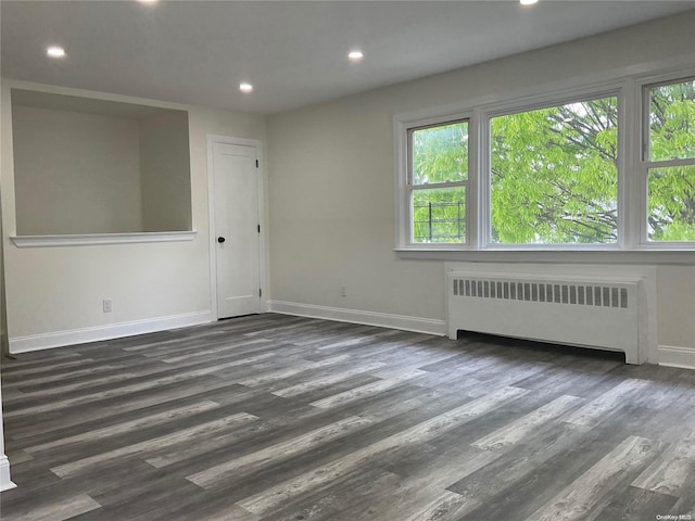 unfurnished room with dark hardwood / wood-style floors and radiator