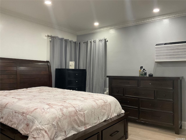 bedroom featuring a wall mounted air conditioner, light wood-type flooring, and ornamental molding