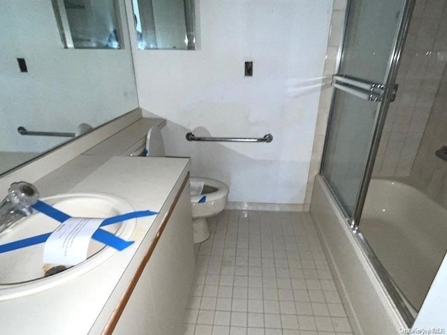 full bathroom featuring shower / bath combination with glass door, tile patterned floors, vanity, and toilet