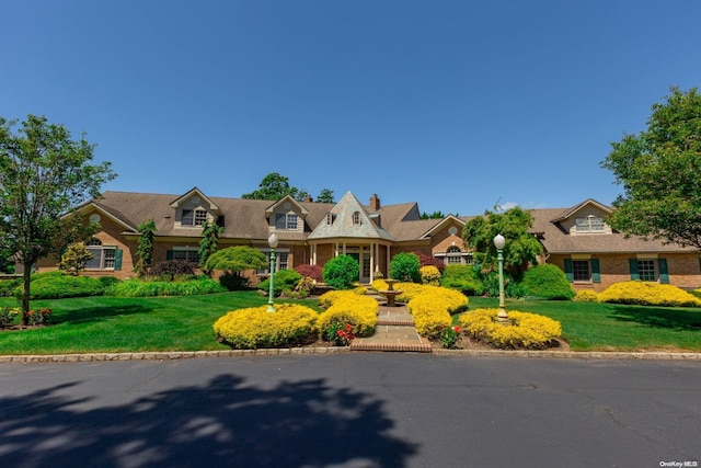 cape cod home with a front yard