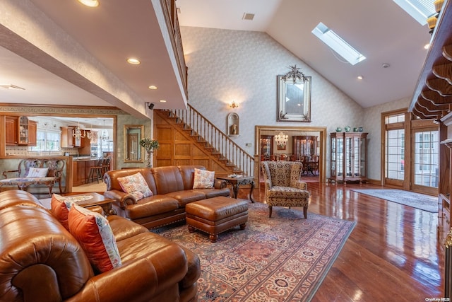 living room with a skylight, hardwood / wood-style floors, and high vaulted ceiling