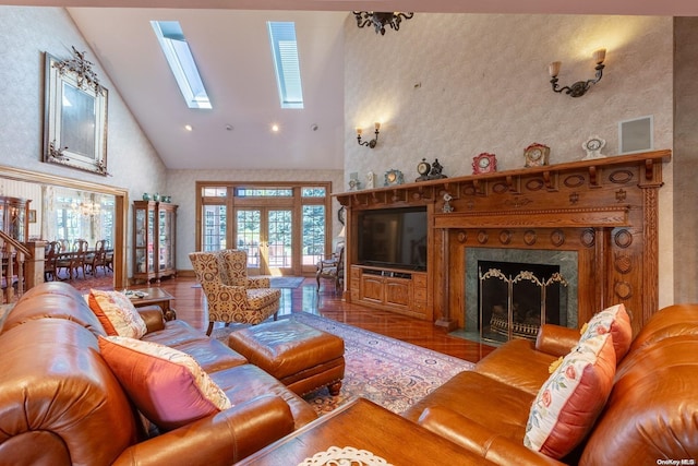 living room with hardwood / wood-style floors, high vaulted ceiling, french doors, a skylight, and a fireplace