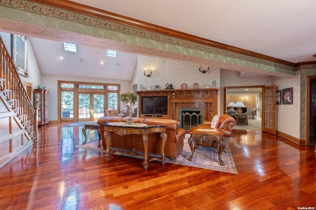 living room with hardwood / wood-style floors, lofted ceiling, ornamental molding, and french doors