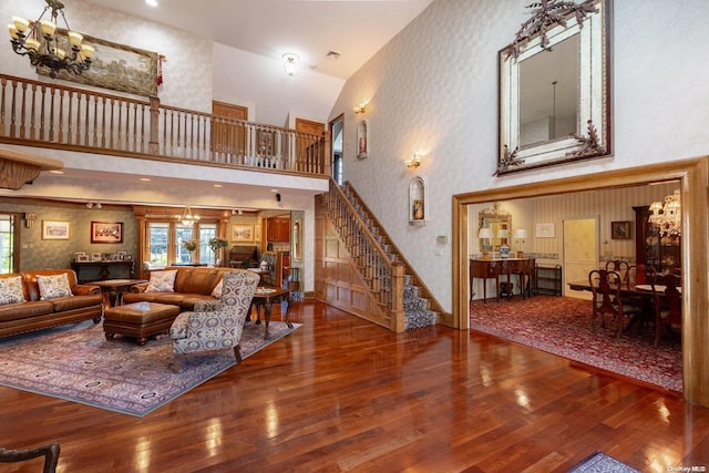 living room featuring high vaulted ceiling, wood-type flooring, and a notable chandelier