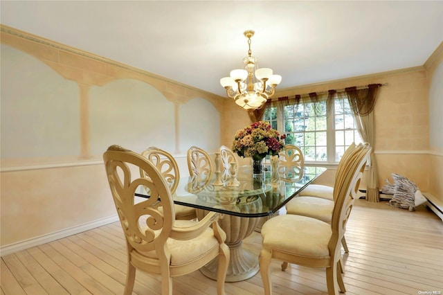 dining space with crown molding, a chandelier, and light wood-type flooring