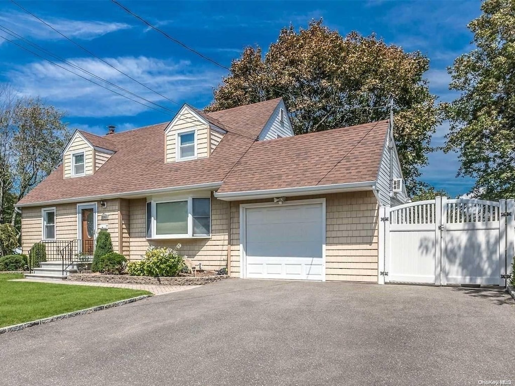 cape cod home featuring a garage