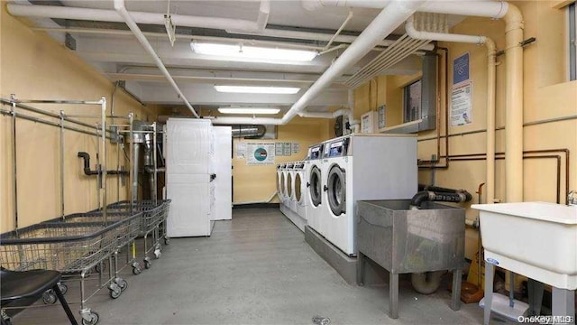 clothes washing area with washing machine and dryer and sink